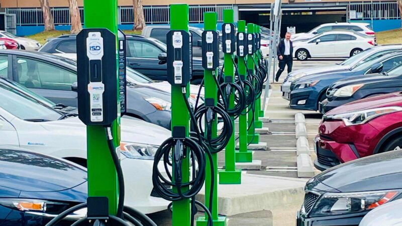 Electric vehicle charging stations lined up in a parking lot, promoting clean transportation in the community.