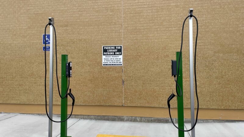 Two electric vehicle charging stations in a designated parking area, promoting clean transportation access.