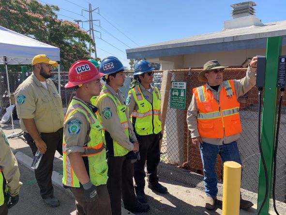 Workers in safety gear listen to a trainer at a clean transportation workshop in Los Angeles County.