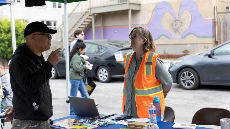 A community member engages with a representative at a clean transportation event in East Los Angeles.